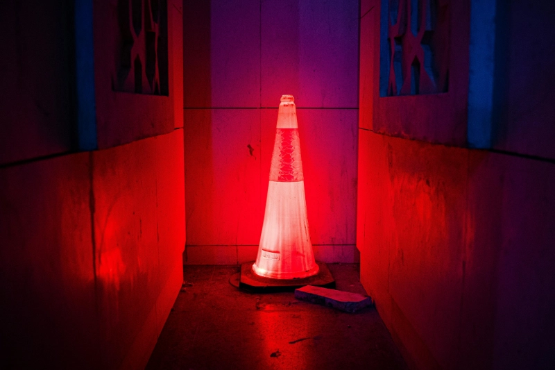 A traffic cone illuminated red in a dark hallway symbolizing 5 Red Flags to Watch for When Hiring a Remodeler